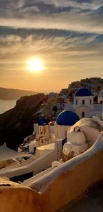 Aerial view of town by buildings against sky during sunset