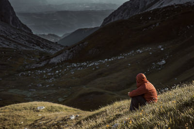 Man sitting on mountain during winter