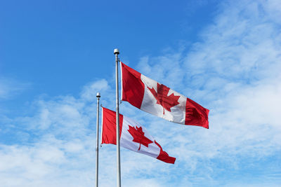 Low angle view of flag against blue sky