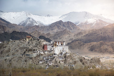 Scenic view of townscape and mountains against sky