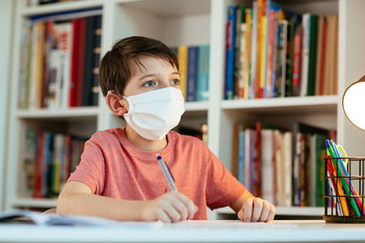 Portrait of boy sitting on book