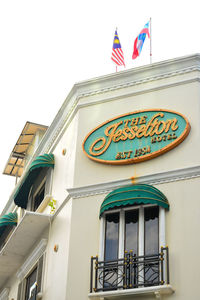 Low angle view of text on building against sky