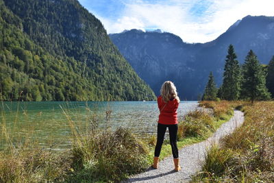 Rear view of woman standing at lakeshore