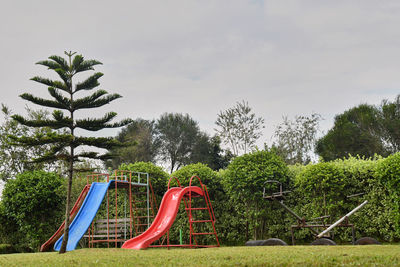 Empty playground against trees in park