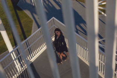 High angle portrait of young woman seen through railing