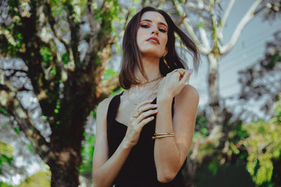 Beautiful young woman standing against plants