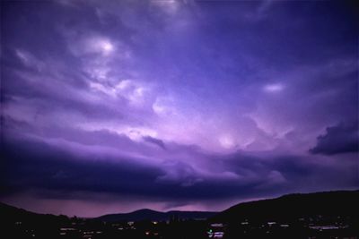 Scenic view of dramatic sky over silhouette mountains