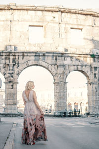 Woman sitting on historical building
