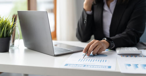 Midsection of businessman working on table