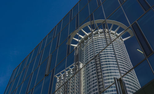 Low angle view of skyscrapers against blue sky