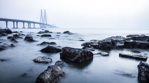 Bridge over sea against clear sky