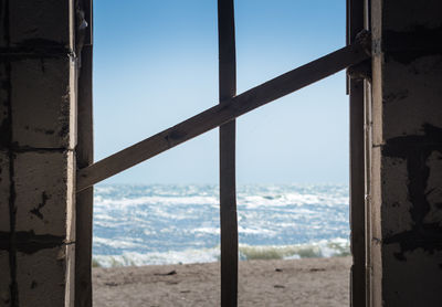 Scenic view of sea against clear sky seen through window