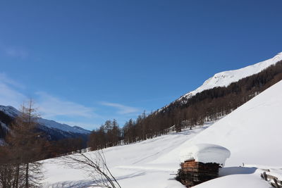 Scenic view of snowcapped mountains against blue sky