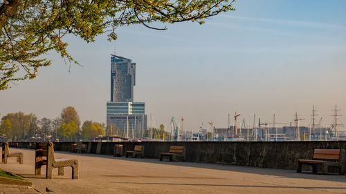 Man on road by buildings against sky