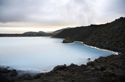 Scenic view of sea and mountains against sky