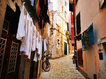 People on narrow street amidst buildings in city