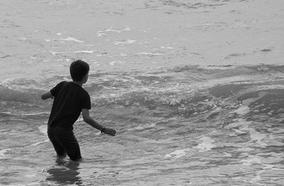 Rear view of boy standing on beach