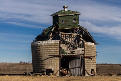 Traditional windmill on field against sky