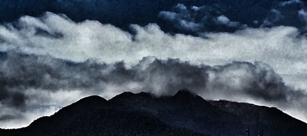 Scenic view of mountains against cloudy sky