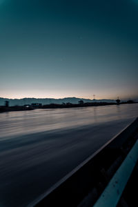 Scenic view of lake against clear sky at sunset