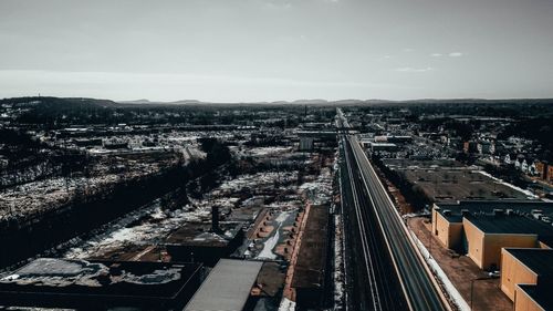 High angle view of railroad tracks amidst buildings in city against sky