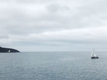 Sailboat sailing on sea against sky