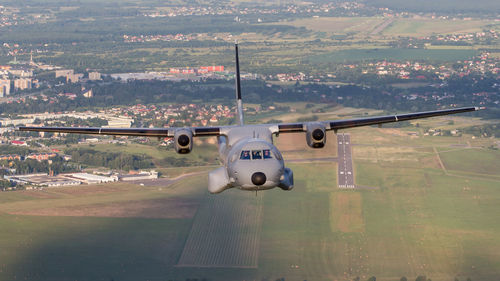 Airplane flying over runway against sky