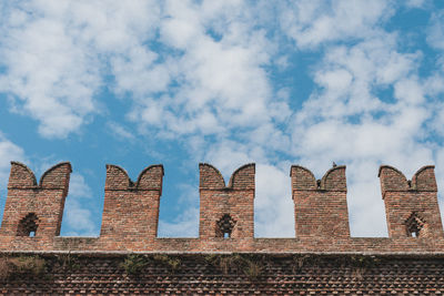 Low angle view of building against cloudy sky