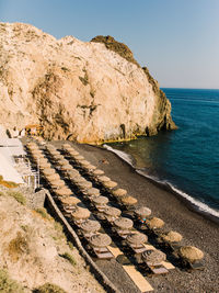 Scenic view of rocks on beach against clear sky