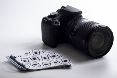 Close-up of camera on table against white background
