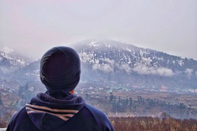 Rear view of man against mountains and sky