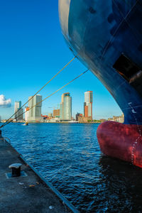 Sea by buildings against blue sky