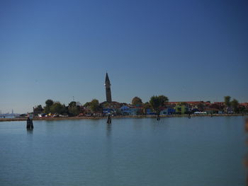 View of river by building against clear sky