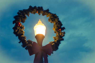 Low angle view of illuminated street light against sky