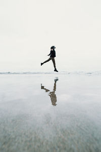 Full length of woman jumping at beach