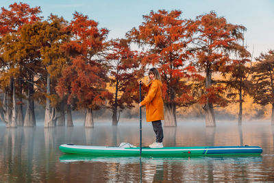 Rear view of man standing in boat in lake