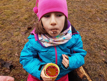 Trekking kid drinking hawthorn tea and eating chocolate in the outdoors