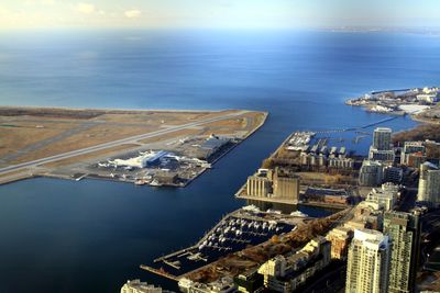 High angle view of cityscape by sea against sky