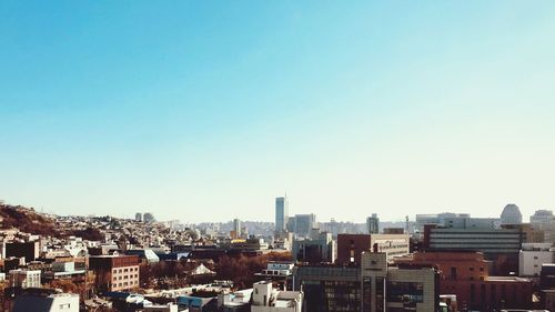 Cityscape against clear blue sky