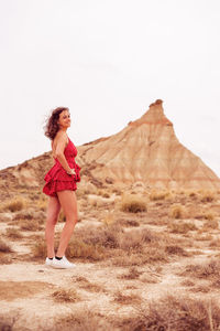 Full length of woman standing on land against sky