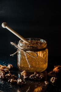 Close-up of jar on table against black background