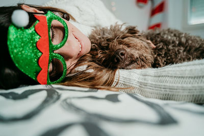 Young woman relaxing with dog on bed at home