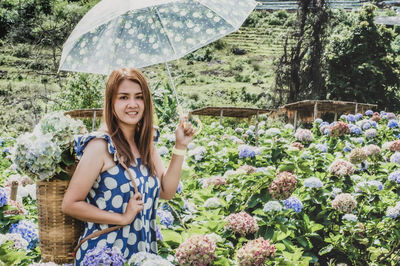 Woman standing by flowering plants