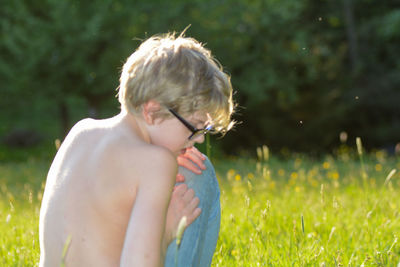 Midsection of shirtless boy on field