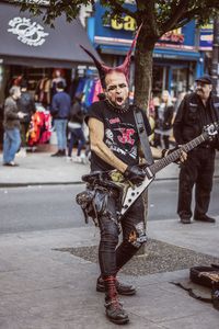 People playing guitar on street in city