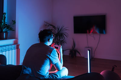 Rear view of woman sitting at home