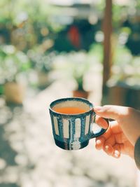 Person holding drink against blurred background