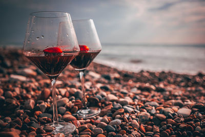 Close-up of red wine in glass at sea shore