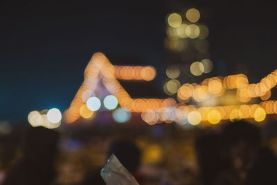 Defocused image of illuminated lights in city at night