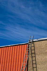 Low angle view of red building against blue sky